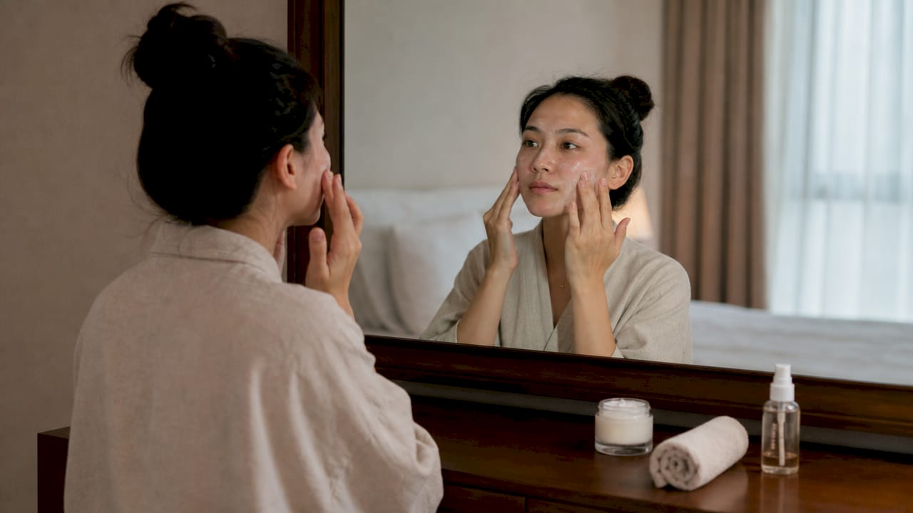 Woman applying skincare cream for rosacea