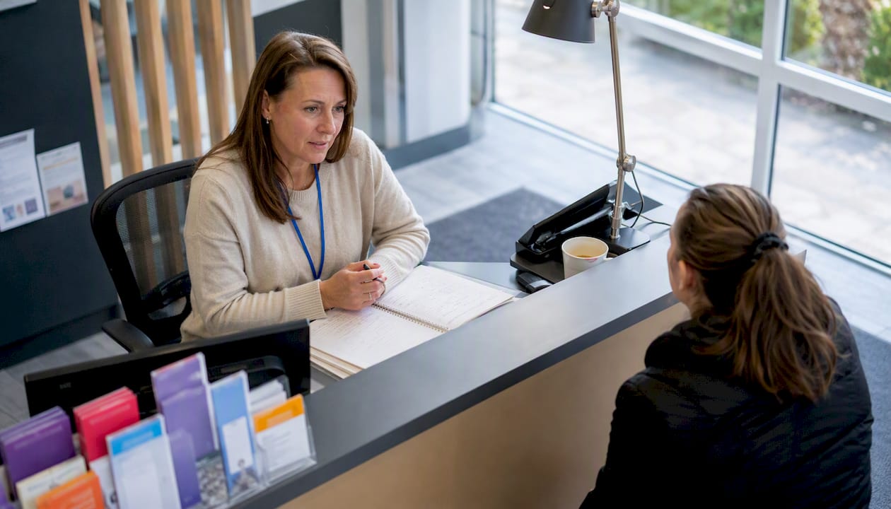 Clinic receptionist listening to patient complaint