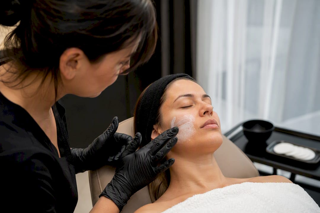 Clinician applying numbing cream to patient’s cheek