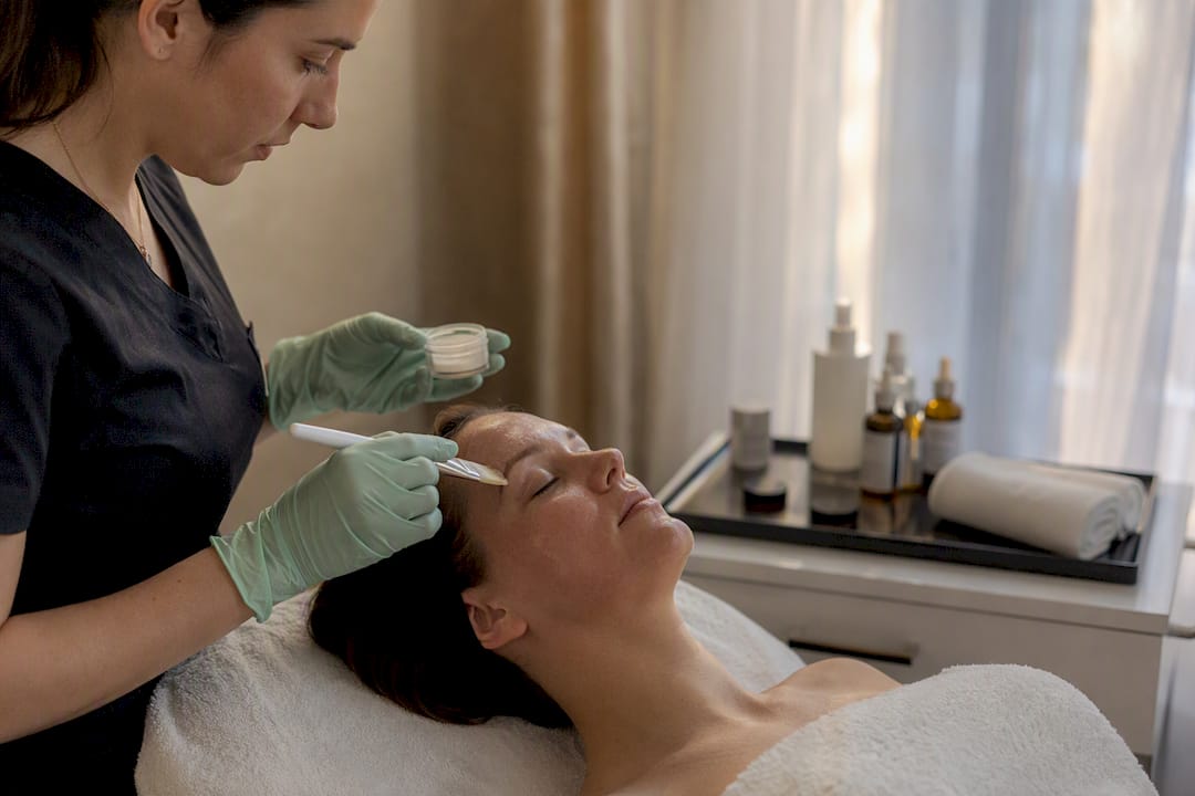 Clinician applying chemical peel to cheek
