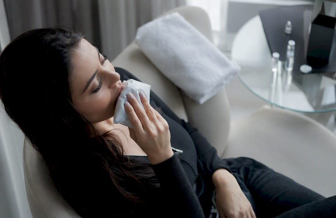 Woman applying cold compress to swollen lips