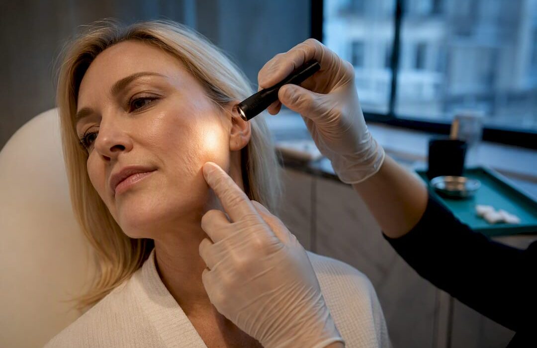 Clinician assessing facial skin after filler