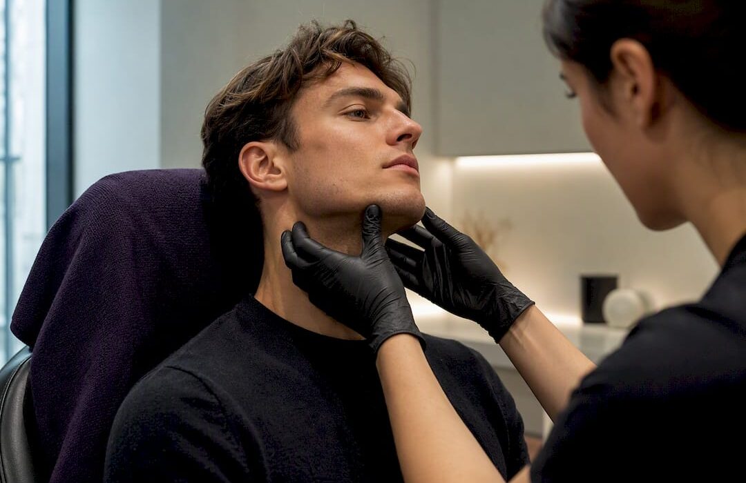 Clinician assessing male jawline contour